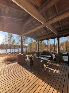 a large wooden deck with chairs and a table at Kalliorinteen Mökit Lehtipirtti in Töysä