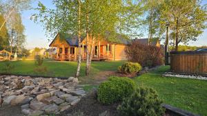 a log cabin with a rock garden in front of it at VIP VILLAGE Las Woda Rower - Podgrzewany Basen, Balia, Sauna in Miedzierza