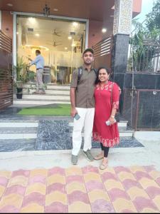 a man and a woman standing in front of a building at Hotel Empress Grand in Tājganj +3 photos