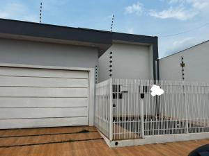 a house with two garage doors and a fence at Casa de temporada Tarumã in Tangara da Serra