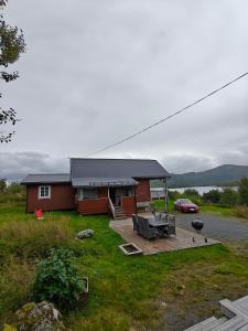 a house with a picnic table and a grill at Hytte Lødingen Vestbygd, når Lofoten, med utsikt in Lødingen