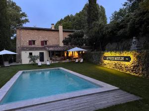 a swimming pool in the yard of a house at Le Vieux Moulin de Jouques in Jouques