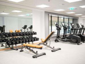 a gym with a lot of exercise equipment and mirrors at IBIS STYLES MUENCHEN AIRPORT in Munich