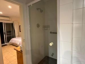 a shower with a glass door in a bathroom at Adorable Pool Side Apartment in Monte Vista +8 photos