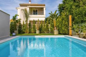 a swimming pool in front of a house at Magdalena Home Corfu in Corfu