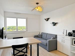 a living room with a table and a couch at Studio entre mer et forêt in Saint-Jean-de-Monts