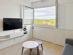 a living room with a tv and a table at Studio entre mer et forêt in Saint-Jean-de-Monts