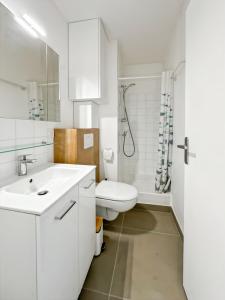 a white bathroom with a toilet and a sink at Studio entre mer et forêt in Saint-Jean-de-Monts +9 photos