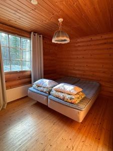 a bedroom with a bed in a wooden room at Kalliorinteen Mökit Suvipirtti in Töysä