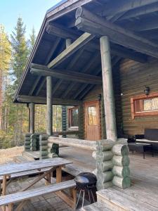 a log cabin with a picnic table and a grill at Kalliorinteen Mökit Suvipirtti in Töysä