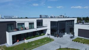 a large white building with people on the balcony at Soccer Box Pro in Dachnów