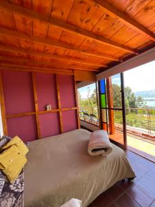 a bedroom with a bed with a large window at Mirador Valeisa in Guatavita