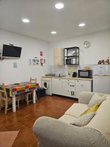 a living room with a couch and a table and a kitchen at Zabava Sacavém in Sacavém