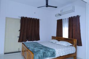 a bedroom with a wooden bed and a window at Sarva Tranquil home stay in Kumbakonam