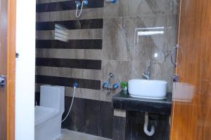 a bathroom with a sink and a toilet at Sarva Tranquil home stay in Kumbakonam +11 photos