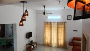 a living room with a curtain and a tv at Sarva Tranquil home stay in Kumbakonam