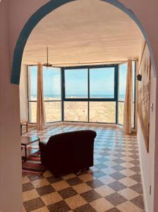 a living room with a couch and large windows at Résidence 3 M in Jāmi‘ al Guelloufi