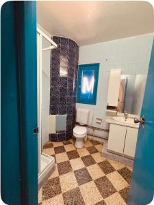 a bathroom with a toilet and a sink and a tub at Résidence 3 M in Jāmi‘ al Guelloufi
