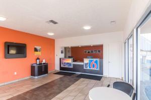a room with orange walls and a kitchen with a counter at Motel 6-Clinton, OK in Clinton