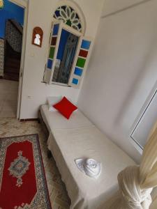 a small room with a bed and a mirror at La Joya Hostel Chafchaouen Cozy Stay with Terrace in Chefchaouen