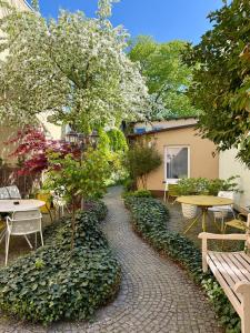 a walkway with tables and benches and a tree at NORDÉA Apartments in Rostock