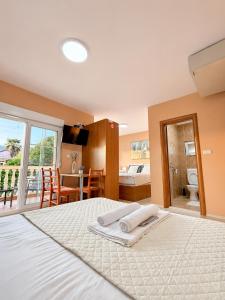 a bedroom with a large white bed and a bathroom at Apartmani Villa Amfora - Free Parking in Neum