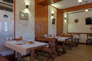 a restaurant with tables and chairs in a room at Hotel Demaj in Berat
