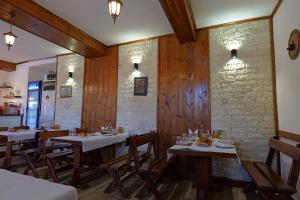 a restaurant with wooden walls and tables and chairs at Hotel Demaj in Berat