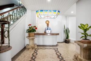a man standing at a counter in a room with a laptop at The Royal Guesthouse in Faro +54 photos