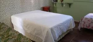 a bedroom with a bed with a white blanket on it at hospedagem quarto suite n1 casa da wal in Goiás +4 photos