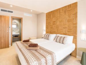 a bedroom with two beds and a bathroom at Hotel Ses Puntetes in Cala d´Or