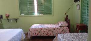 a room with two beds and a chair and a window at hospedagem quarto suite n1 casa da wal in Goiás