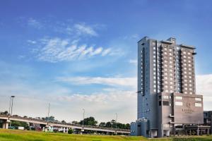 a tall building in front of a train at Millesime Hotel Johor Bahru in Johor Bahru