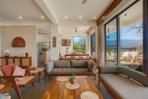 a living room with a couch and a table at The Mountain house 4 BHK VIlla With Pool in Rishīkesh