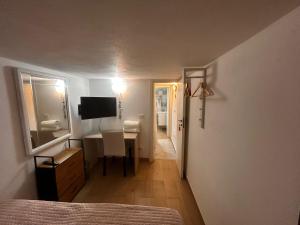 a bedroom with a bed and a desk with a television at L'altra opera in Palermo