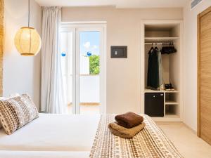 a bedroom with a white bed and a closet at Hotel Ses Puntetes in Cala d´Or +65 photos