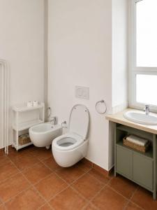 a white bathroom with a toilet and a sink at IN THE HILLS NEAR THE LAKE, Relax e Comfort in Grotte di Castro