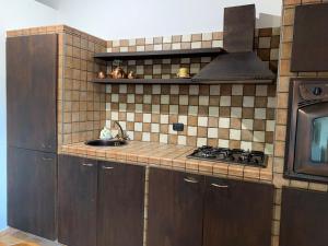 a kitchen with a stove and a sink in it at Momon1616 Intero Chalet in Galatina