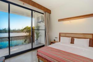 a bedroom with a bed and a balcony at The Mountain house 4 BHK VIlla With Pool in Rishīkesh