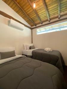 a room with two beds and a window in it at Flats do Pe na Areia in Abraão