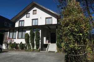 a white house with a lot of windows at Pension Agi in Hakuba