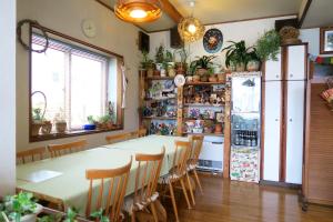 een eetkamer met een tafel en een koelkast bij Pension Agi in Hakuba