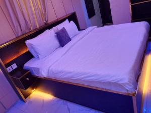 a bed with white sheets and pillows in a room at Triumph Group in Asaba