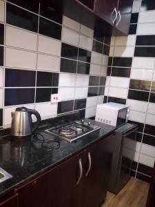 a kitchen with black and white tiled walls at Triumph Group in Asaba