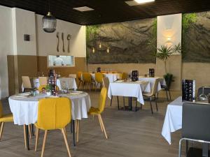 a dining room with white tables and yellow chairs at Hotel Bennington in La Marina