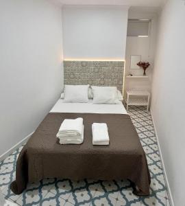 a bedroom with a bed with two towels on it at Elvas Centro Histórico Largo do Refúgio in Elvas