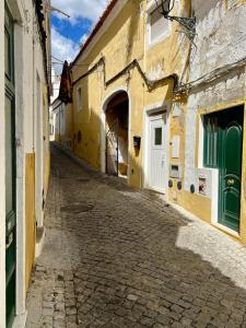 an alley in an old town with yellow buildings at Elvas Centro Histórico Largo do Refúgio in Elvas