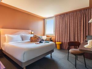 a hotel room with a bed with a backpack on it at IBIS STYLES ALES CENTRE in Alès