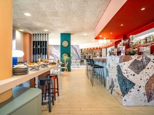 a restaurant with a bar with stools at IBIS STYLES ALES CENTRE in Alès