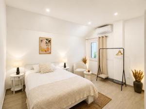 a white bedroom with a bed and a chair at La Perla - Korčula in Korčula